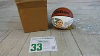 Photo of the Wilson mini Larry Bird basketball with its original box and certificate of authenticity showing number 33 and autograph certification