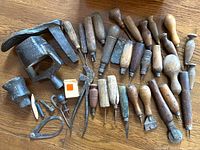 Photo showing assorted vintage hand tools with wooden handles and various metal pieces including a corner clamp and large metal clamp