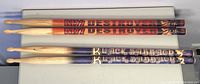 Four drum sticks laid out horizontally, two KISS Destroyer and two Black Sabbath.