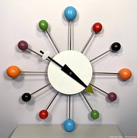 Front view of the George Nelson style orb spoke clock showing colorful orbs and geometric hands.