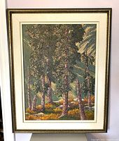 Framed oil painting showing landscape of birch trees with textured bark and foliage set in a forest with rocks and ground cover under bright light.