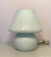 Front view of unlit white glass mushroom lamp showing rounded base and conical shade with swirl pattern