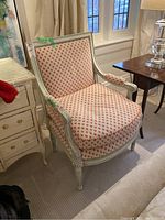 Front angled view showing pink dotted upholstery and carved frame