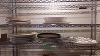 Shelves holding multiple plates and platters including Spode platters and decorative pieces