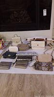 Overview of all ten purses arranged on floor