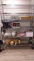 Full front view of chrome wire shelving unit displaying six shelves and caster wheels