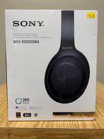 Front of retail box showing Sony branding, model number WH-1000XM4 and price sticker