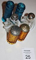 Photo of three pairs of antique glass shakers including blue, white opal fern swirl, and amber hobnail styles with metal tops