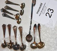 Top down view showing all 5 spoons arranged on bubble wrap and auction tag, highlighting their size and shape differences.