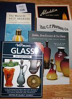 Photo of five art glass reference books laid on blue fabric, showing titles and covers.