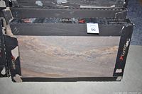 Stacked black Graniser Porcellanato tile boxes showing slate-look pattern on box face
