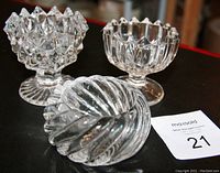 Three Victorian larger glass open salts shown on black background with auction lot number card. Two salts have noticeable rough mold join lines and pedestal bases. Third salt is shorter with smooth spiral ribbed design.