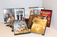 Nine assorted DVD movies including The Magnificent Seven, The Incredibles, The Rock Hudson Collection, Fun In Face, Heartbreakers, The Parole Officer, and two unidentified DVDs.