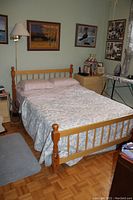 Photo of a double wooden bed frame with box spring in bedroom, no mattress included.
