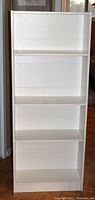 Full front view of white IKEA Billy bookcase showing five shelves and good condition.