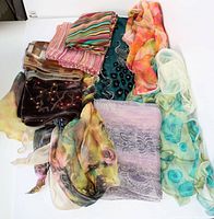 Photo showing nine vintage scarves in various colors, patterns, and fabrics including floral, stripes, geometric, and embellished designs.