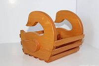 Photo of a handmade wooden plant stand with two bird-shaped sides and a slatted base