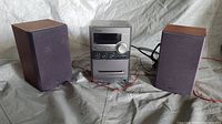 Front view of the Sony stereo system with two speakers, showing the main unit and connected speaker cables.