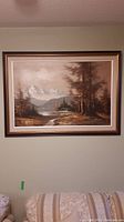 Full view of the framed painting showing a scenic mountain lake landscape.