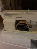 Side and front views of Singer Merritt sewing machine showing stitch patterns and controls