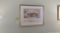 Framed limited edition print of a winter house scene by Trisha Romance with a gold frame and white double mat.