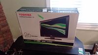 Front view of the original Toshiba TV box showing model number 26C100U and 26 inch screen size