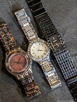 Three DKNY ladies wristwatches placed side by side showing overall condition and design details.