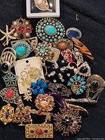 Top view of the assorted brooch collection showing the variety of designs, colors, and materials used in the costume jewelry brooches.