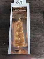 Box showing 10 inch glitter Christmas tree decoration with LED lights, gold color, battery operated.