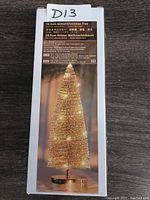 Photo of the product box showing the tree on the front with gold glitter and LED lights.