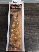 Box of the 14 inch glitter Christmas tree showing image of tree lit up with LED lights and product details on front of box.