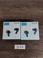 Front view of two boxed Soundcore Life P2 Mini earbuds, one black and one navy, showing product name and key features like 'Mini Buds Big Bass' and 32H playtime.