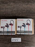 Two sealed boxed units of Parasom Super Headset A19 wireless sport earphones shown from front with earbuds and neckband visible.