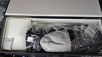 Box with grey and black heated socks size Small, sealed in plastic with rechargeable battery packs and accessories, new in packaging.