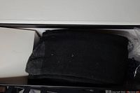 Photo showing the pair of black heated socks folded in a box.
