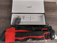 Open box containing the rechargeable heated socks, battery pack, and charger.