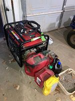 Front-left view of generator with attached fuel cables and cans on floor