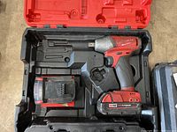 Milwaukee M18 Fuel 1/4 inch hex impact driver with red lithium battery and charger in molded red carrying case.