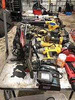 Overview of tools on table including DeWalt power tools, chargers, saw and accessories