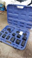 Full view of blue molded carrying case with 12 black metal tool accessories arranged in custom slots.