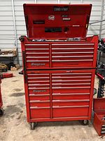 Full front view of red Snap-on rolling tool chest with top lid open showing upper section and lower cabinet