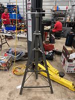 Full view of the Pittsburgh 2 Ton Underhood Safety Stand in a workshop environment with other tools and equipment around.