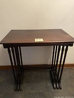 Front view of the largest table showing dark wood and turned spindle legs
