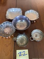 Photo showing four silverplated bowls with tarnish and patina, varied scalloped and smooth edges.