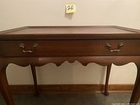 Front view of mahogany side table showing drawer and cabriole legs.