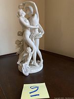 Full front view of sculpture showing embracing couple and cherubs