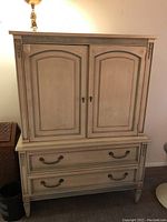 Full front view of wooden cabinet chest showing two upper doors and two lower drawers, distressed painted finish with some scratches and stains visible.