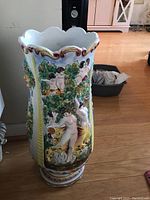 Front side showing nude figures dancing and resting in relief with leaves and floral decoration