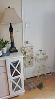 Full lot view including lamp, calendar, frog figurine, flower wire rack, and shower caddy on door and nearby surfaces.
