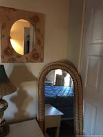 Alternate view of tall woven arched mirror near door and furniture.